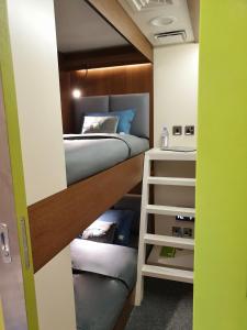 Habitación con 1 cama y 1 litera en sleep 'n fly Sleep Lounge, C-Gates Terminal 3 - TRANSIT ONLY, en Dubái