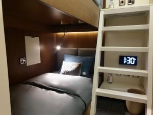 een slaapkamer met 2 stapelbedden en een wekker bij sleep 'n fly Sleep Lounge, C-Gates Terminal 3 - TRANSIT ONLY in Dubai