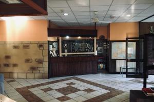 a bar in a restaurant with a tile floor at RistHotel Pianura Inn in Busnago