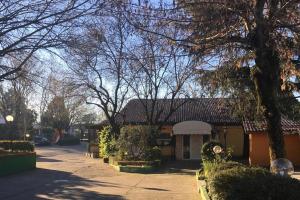 un patio con árboles y una casa con entrada en RistHotel Pianura Inn, en Busnago