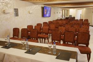 einen Konferenzraum mit Tischen, Stühlen und einem Bildschirm in der Unterkunft Hotel Vrbak ND in Novi Pazar