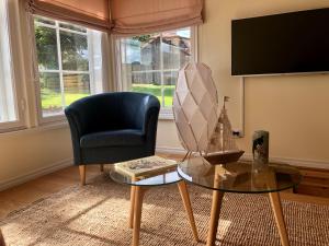 a living room with a chair and a glass table at Ryytlihaus Old Town Apartement in Haapsalu