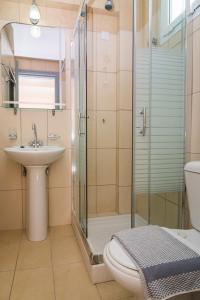 een badkamer met een douche, een toilet en een wastafel bij Macedonia in Kalamaki