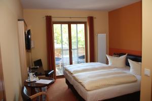 a hotel room with a bed and a balcony at Badehaus Hotel & Restaurant in Neubrandenburg
