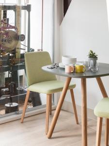 una mesa con 2 sillas y una mesa con tazas en Wittenberg by Cove, en Ámsterdam