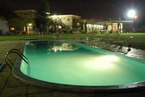 een groot zwembad 's nachts in een tuin bij PARQUE APART HOTEL in San Juan