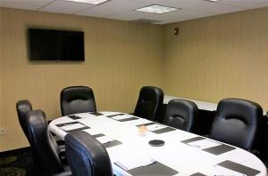 une salle de conférence avec une table, des chaises et une télévision dans l'établissement Holiday Inn Express Hotel & Suites Pittsburgh Airport, an IHG Hotel, à Robinson Township