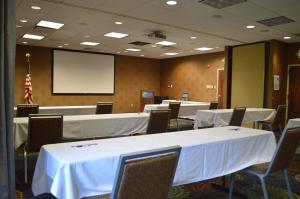 una sala conferenze con tavoli e sedie bianchi e schermo di Holiday Inn Express Hotel & Suites Pittsburgh Airport, an IHG Hotel a Robinson Township
