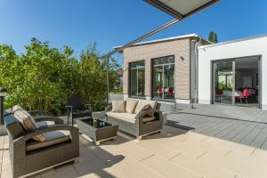 eine Terrasse mit Stühlen und einer Couch auf einer Terrasse in der Unterkunft Sporthotel Grünberg in Grünberg