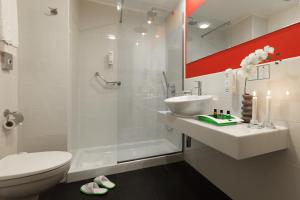 um banheiro com chuveiro, pia e vaso sanitário em Holiday Inn Genoa City by IHG em Génova