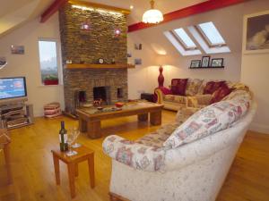 a living room with a couch and a fireplace at Fourteens Holiday Home Ballinskelligs in Ballinskelligs