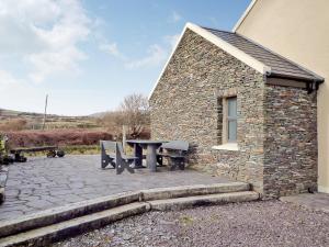 a picnic table and bench outside of a building at Fourteens Holiday Home Ballinskelligs in Ballinskelligs