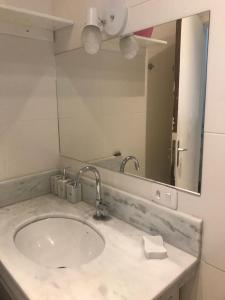 ein Badezimmer mit Waschbecken und Spiegel in der Unterkunft Beach House in Ubatuba + 22 Fotos