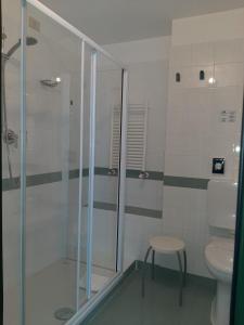 a bathroom with a shower and a toilet and a stool at Hotel Tirreno in Genoa
