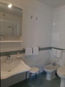 a bathroom with a sink and a toilet and a mirror at Hotel Tirreno in Genoa