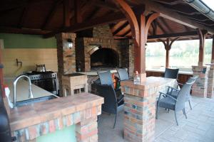 een patio met een buitenkeuken met een bakstenen oven bij Vila Odmor na Dunavu in Beočin