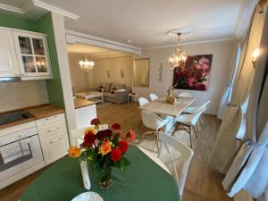 Ferienwohnung Giacomelli 4 في روتاش ايجرن: مطبخ وغرفة معيشة مع طاولة مع إناء من الزهور +7 صور