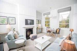 a living room with blue furniture and a fireplace at 50 London Road - By Luxury Apartments in Cheltenham