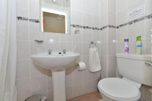 uma casa de banho com um WC branco e um lavatório. em Willows em Calbourne