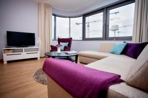 a living room with a couch and a tv at Silver Apartments in Wrocław