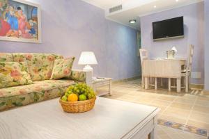 a living room with a couch and a basket of fruit on a table at Royal Son Bou Family Club in Son Bou