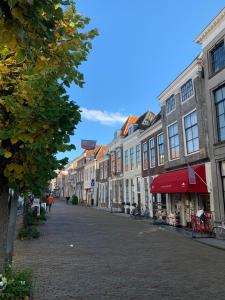 a cobblestone street in a city with buildings at De Maecht van Mechelen in Zierikzee