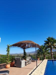 un patio con sombrilla junto a una piscina en Villafranco Apartamentos en Villafranco de Guadalhorce