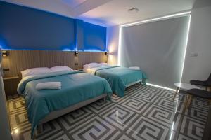 金巴亚PARIS. HOTEL的一间蓝色墙壁的房间里有两张床