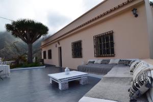 un patio con sofá y mesa frente a un edificio en Casa Noni, en Santa Cruz de Tenerife