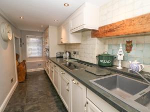a kitchen with a sink and a counter top at Millstream Cottage in Castleton