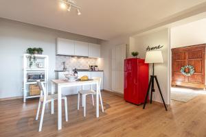 een keuken met een witte tafel en een rode koelkast bij La Grande Finestra - Appartamento con giardino in Chiusi