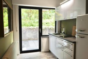 een keuken met witte kasten en een groot raam bij Seven in Koblenz