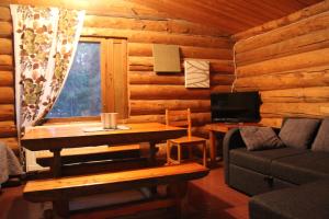 a log cabin living room with a table and a couch at Cottages RukaTupa in Ruka
