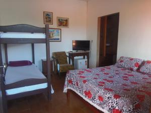 a bedroom with a bed and a bunk bed at Pousada Paraguaya in Angra dos Reis