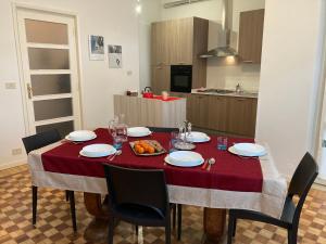 een eettafel met een rode tafelkleed en stoelen bij Casa I Tre by Holiday World in Cuneo