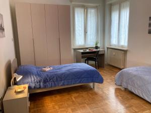 een slaapkamer met 2 bedden, een bureau en een tafel bij Casa I Tre by Holiday World in Cuneo