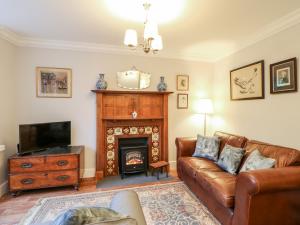 a living room with a couch and a fireplace at Hawthorne Cottage in Barnard Castle