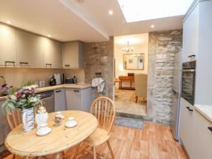 a kitchen and dining room with a wooden table and chairs at Hawthorne Cottage in Barnard Castle