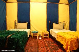 a room with two beds in a tent at Ouzina Desert Camp in Ouzina
