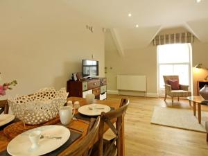 a dining room and living room with a table and chairs at Harlech Apartments - Efnisien in Harlech