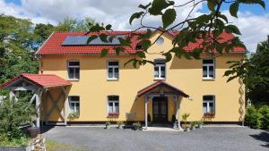 アイゼナハにあるHaus Eveline - Ferienwohnungen unterhalb der Wartburg -の赤屋根の黄色い家