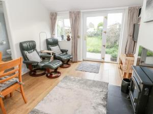 a living room with two chairs and a table at Bwthyn in Moelfre