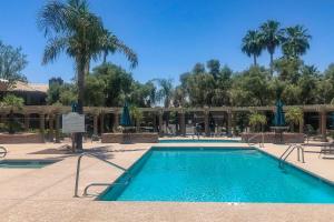 a swimming pool at a resort with palm trees at Scottsdale Condo with Pool Walk to Kierland Resort in Scottsdale