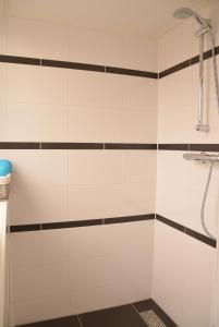 baño con cabina de ducha con rayas blancas y negras en De Sprink - Vakantiewoning, en Zoutelande