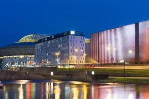 a building next to a river at night at Jaz in the City Amsterdam in Amsterdam