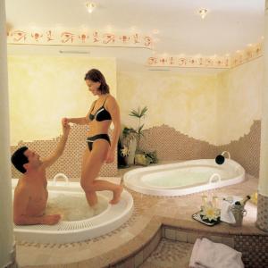 Ein Mann und eine Frau in einem Badeanzug in einer Badewanne. in der Unterkunft Hotel Residence Lorenz in Gossensaß