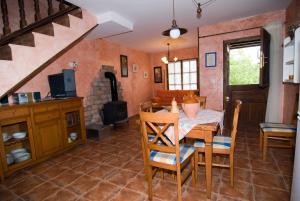 a kitchen with a table and chairs and a staircase at Casa Les Pedroses in Campiellos