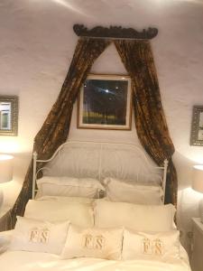 a bedroom with a bed with a window and white pillows at Finca La Sabina in Risco Blanco
