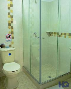 a bathroom with a toilet and a glass shower at HOTEL QUILICHAO in Santander de Quilichao