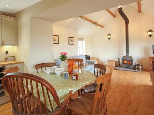 a kitchen and dining room with a table and a stove at Ty Capel Bryntwrog in Holyhead
